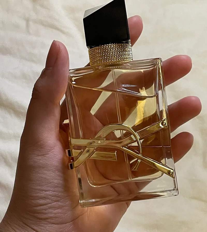 Frascos de perfume de 30 ml, 50 ml y 100 ml en la mano