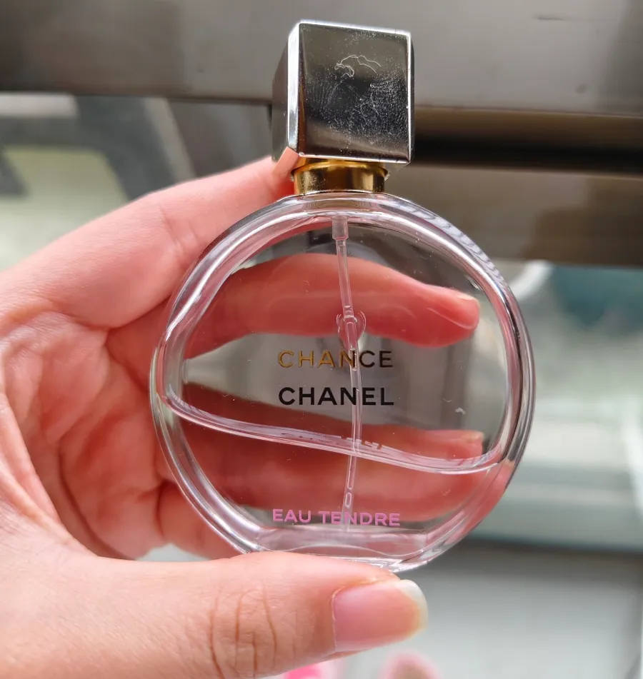 Frascos de perfume de 30 ml, 50 ml y 100 ml en la mano