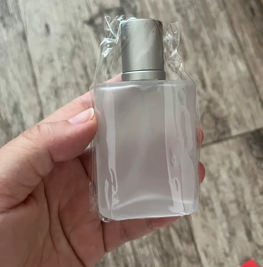 Frascos de perfume de 30 ml, 50 ml y 100 ml en la mano