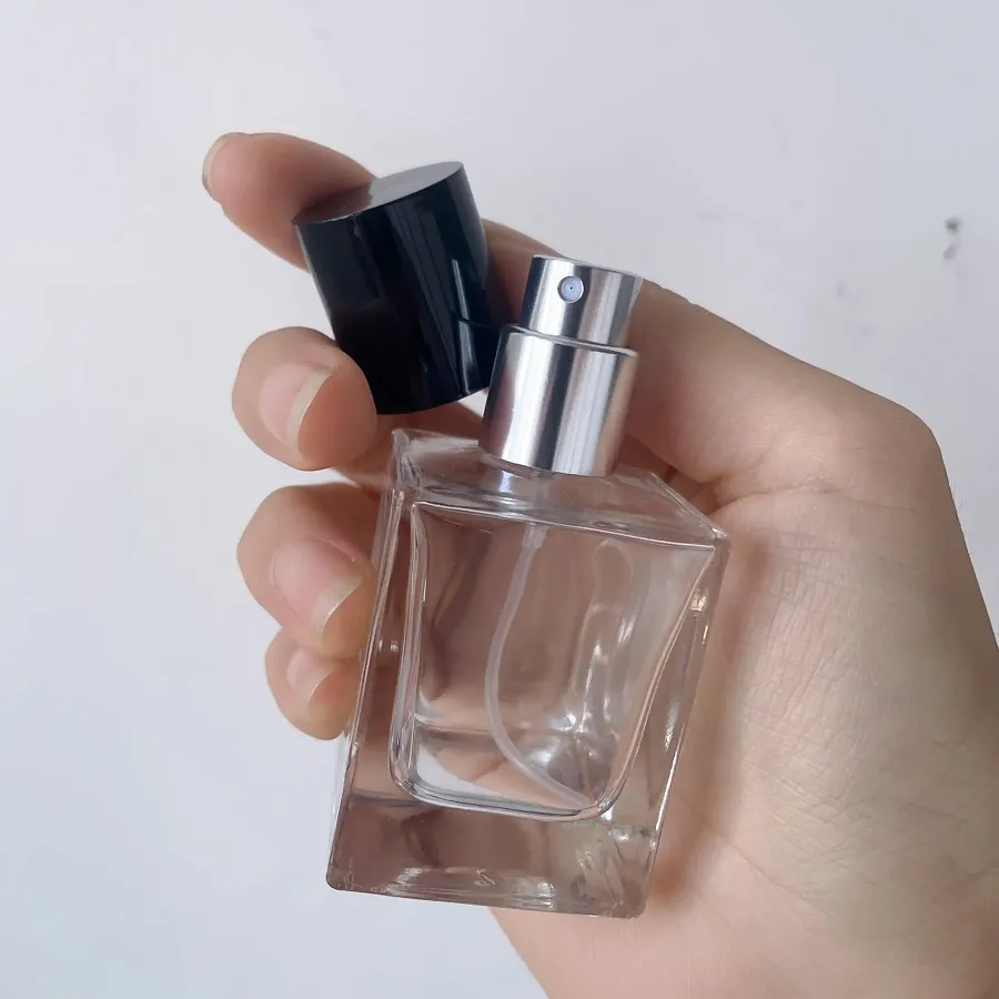 Frascos de perfume de 30 ml, 50 ml y 100 ml en la mano