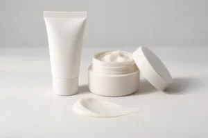 Tubo pequeño de crema facial y frasco mini, comparados con la misma textura de crema